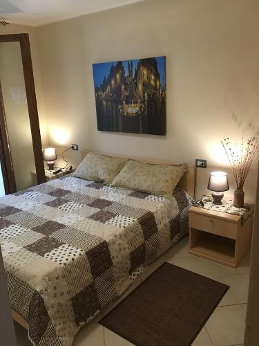 une chambre avec un lit et un tableau au mur dans l'établissement Castelsardo Romantica, à Castelsardo