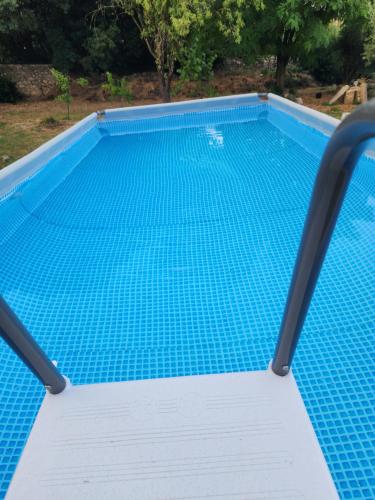 a blue swimming pool with a diving board in it at Charme et piscine dans le Gard salon et deux chambres in Sommières