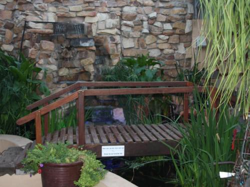 a wooden bench sitting in front of a stone wall at Klawer Hotel in Klawer