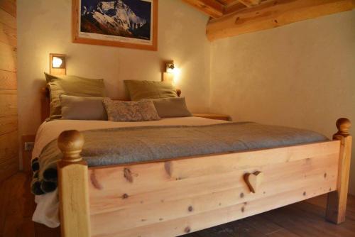 une chambre avec un lit en bois dans une pièce dans l'établissement Chalet Ciamarella, à Lanslevillard