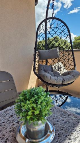 a basket chair sitting on a table with two plants at Sea & Sun 4* in Banjole