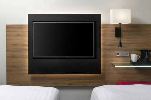 a flat screen tv on a wall in a bedroom at Moxy Southampton in Southampton