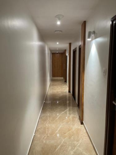 a hallway with white walls and a long hallway at Hotels Heraa International in Mumbai