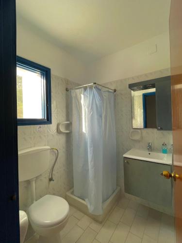 Un baño con ducha, inodoro y lavabo. en Ardani Bay Studios, en Amoopi