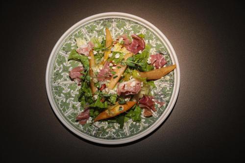 a plate of salad with meat and vegetables on a table at Best Western Premier Batumi in Batumi