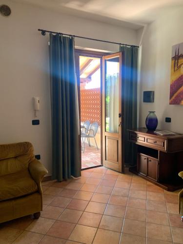 a living room with a couch and a sliding glass door at Residenza Le Querce Trilocale in Fossato di Vico