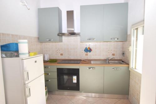 Una cocina con un refrigerador blanco y un fregadero. en Villino RAMERINO, en Marina di Campo Airport