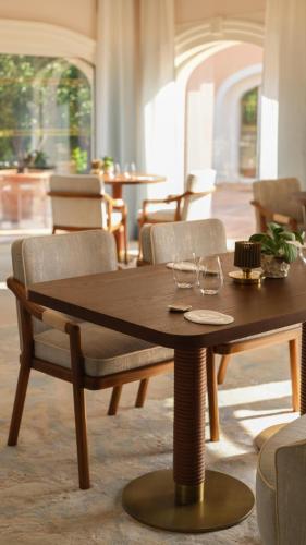 a wooden table and chairs in a living room at Villa Miraé by Inwood Hotels - Cap d'Antibes in Antibes