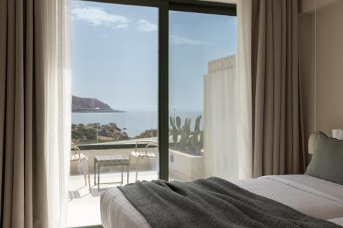 a bedroom with a bed and a view of the ocean at Cavo Marelia in Amoopi
