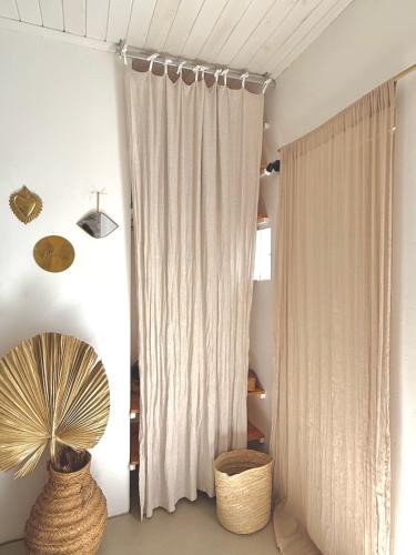 a room with a curtain and a fan and a window at La Kazaka Terre Sainte in Saint-Pierre