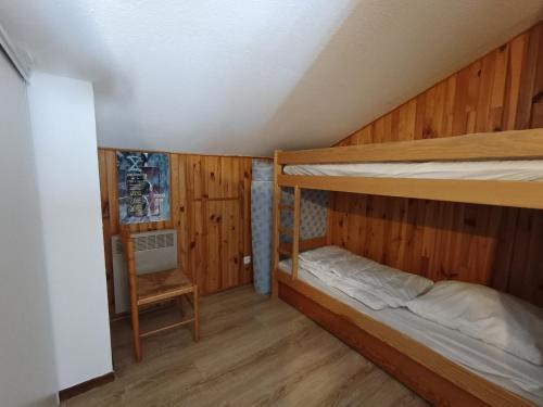 - une chambre avec 2 lits superposés et une chaise dans l'établissement Duplex ski aux pieds, 6 pers, animaux acceptés, Wi-Fi, parking - FR-1-445-94, à Montgenèvre