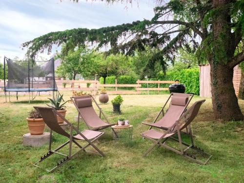 two chairs sitting in the grass under a tree at Gîte Demilenise - Villemain in Villemain