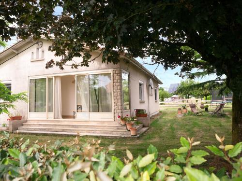a white house with a porch and a yard at Gîte Demilenise - Villemain in Villemain