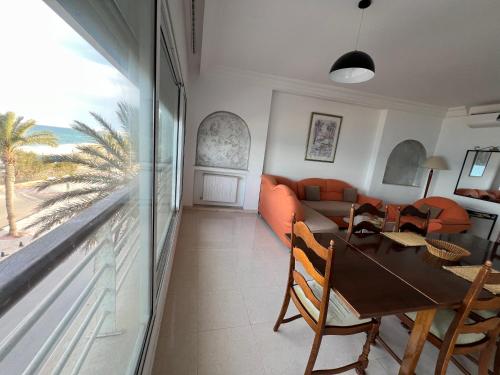 a living room with a table and a couch at Mahdia front sea balcony 2 in Hiboun