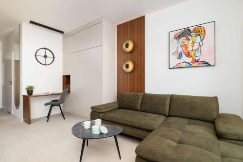 a living room with a couch and a table at Bright Studio in Katowice with Parking, Sauna & Gym by Noclegi Renters in Katowice