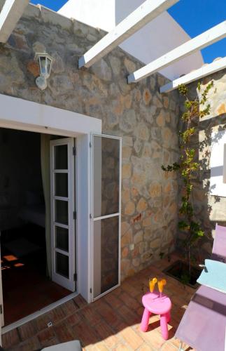 a patio with a door and a pink table at Moinhos das Marés in Fuzeta