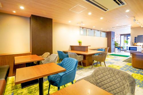 a waiting room with tables and chairs at Hotel New Gaea Yanagawa in Yanagawa