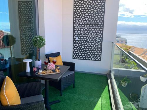 a balcony with a table and chairs and a window at VILLA HELENA Amber Apartment in Caniço