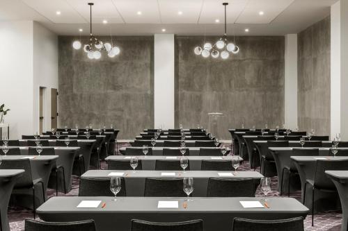 an empty room with tables and chairs and chandeliers at Kimpton Everly Hotel Hollywood by IHG in Los Angeles