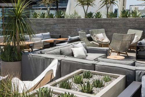 a patio with couches and chairs and potted plants at Kimpton Everly Hotel Hollywood by IHG in Los Angeles
