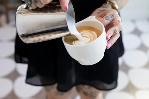 a person is holding a cup of coffee at Kimpton Everly Hotel Hollywood by IHG in Los Angeles