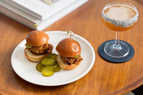 a plate with two pulled pork sandwiches and a drink at Kimpton Everly Hotel Hollywood by IHG in Los Angeles