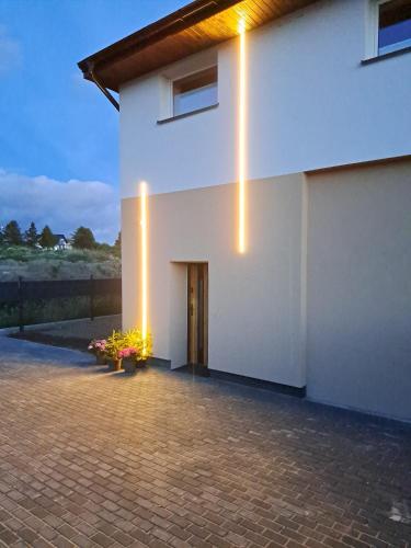 a white building with a door and lights on it at Apartamenty Wałowa 7 in Rewa