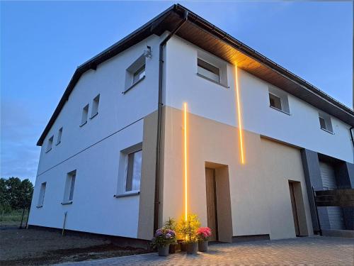 a white building with lights on the side of it at Apartamenty Wałowa 7 in Rewa