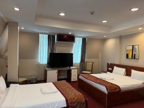 プリシュティナにあるHotel Royalのベッド2台と薄型テレビ付きのホテルの部屋