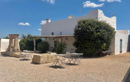 a group of tables and chairs in front of a building at Masseria Caposella in Ugento