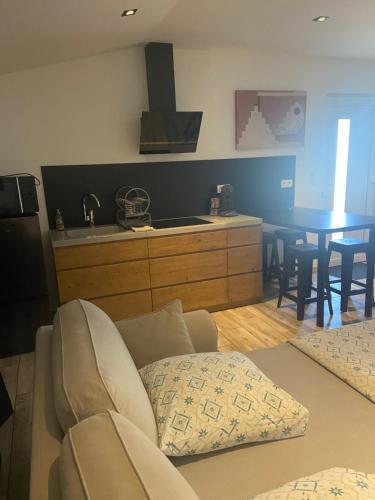 a living room with a couch and a kitchen with a table at Maison indépendante in Venouse