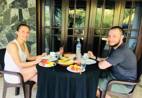 a man and a woman sitting at a table with food at Village Life Mihinthale in Anuradhapura
