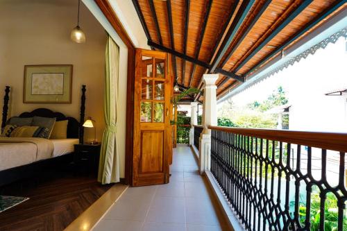 a bedroom with a bed and a wooden door at Tranquil Trails- Amayah Neer 3-BHK Villa Near Assagao in Assagao