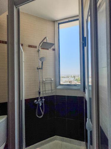 a shower in a bathroom with a window at Sea View City Beach Apartment in Larnaka