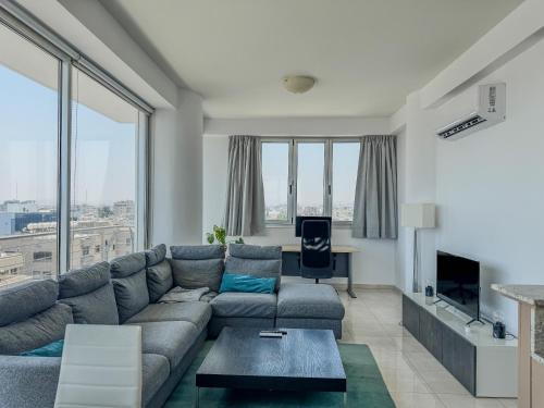 a living room with a couch and a table at Sea View City Beach Apartment in Larnaka