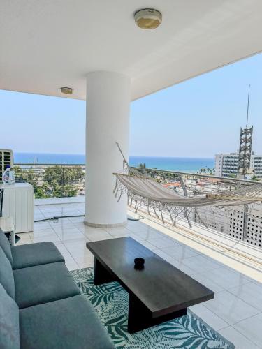 a living room with a couch and a coffee table at Sea View City Beach Apartment in Larnaka