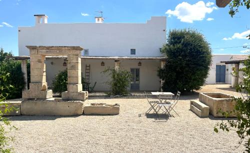 an old building with a table in a courtyard at Masseria Caposella in Ugento
