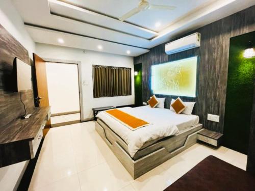 a bedroom with a large bed and a television at Hotel Sai Kripa Chittorgarh AC OR NON AC ROOM in Chittaurgarh