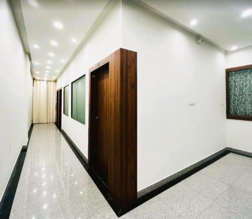 a hallway with white walls and a wooden door at Hotel Sai Kripa Chittorgarh AC OR NON AC ROOM in Chittaurgarh