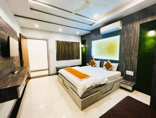 a bedroom with a large bed and a television at Hotel Sai Kripa Chittorgarh AC OR NON AC ROOM in Chittaurgarh