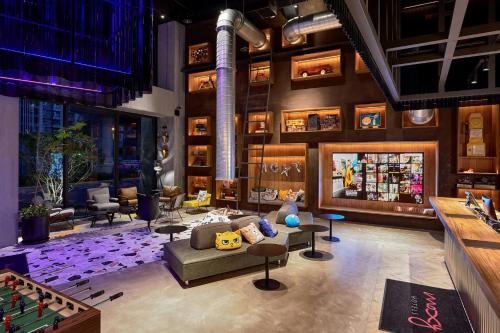a living room with a pool table and a bar at Moxy Taichung in Taichung