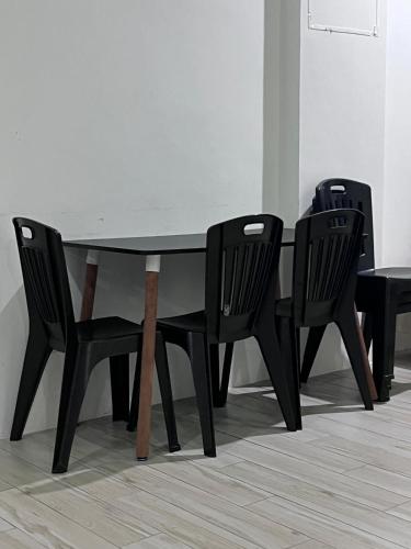 a black dining table with two black chairs around it at Zen 66 apartment in Kuching