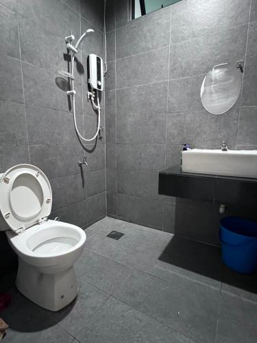 a bathroom with a toilet and a shower and a sink at Zen 66 apartment in Kuching