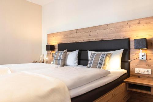 a bedroom with a large bed with a wooden headboard at Hotel Dirsch Wellness & Spa Resort in Emsing