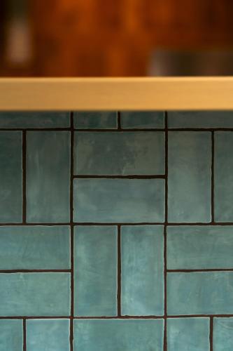 a counter top with blue tiles on it at Roberta's Society Aarhus in Aarhus