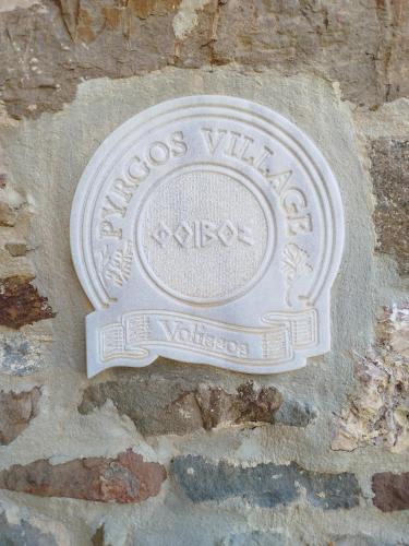 a sign on the side of a stone wall at Volissos Sea View Maisonettes in Volissos