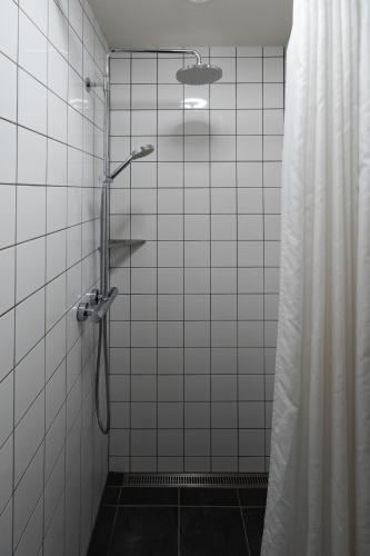 a shower in a tiled bathroom with a shower curtain at Roberta's Society Aarhus in Aarhus