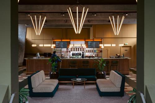 a lobby with two chairs and a bar in the background at Roberta's Society Aarhus in Aarhus