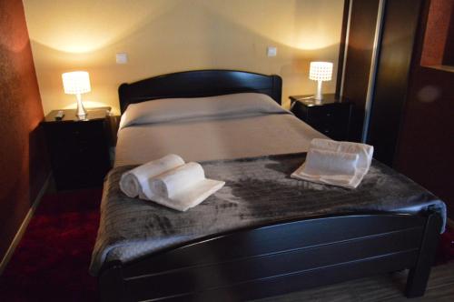 a bedroom with a bed with two towels and two lamps at Casa Vale Quintao in Geres