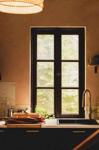 a window over a kitchen counter with a sink at AŻ POD LAS in Zbiczno